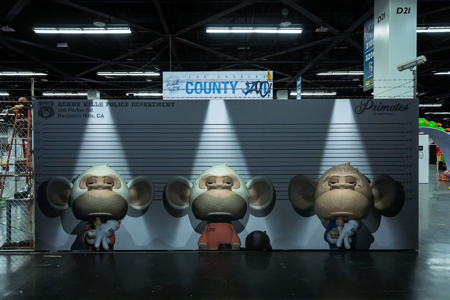 A mugshot height-chart wall with oversized Primate figures, marked ‘Benny Hills Police Department.’