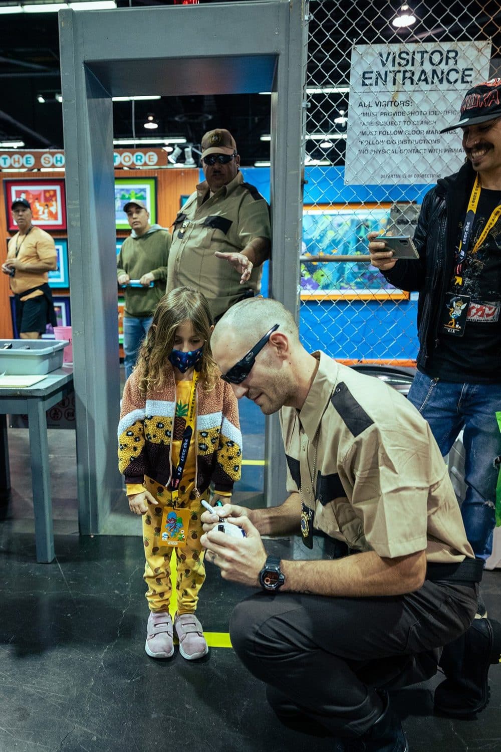 A costumed guard signs a vinyl figure for a young visitor at the mock ‘Visitor Entrance.’
