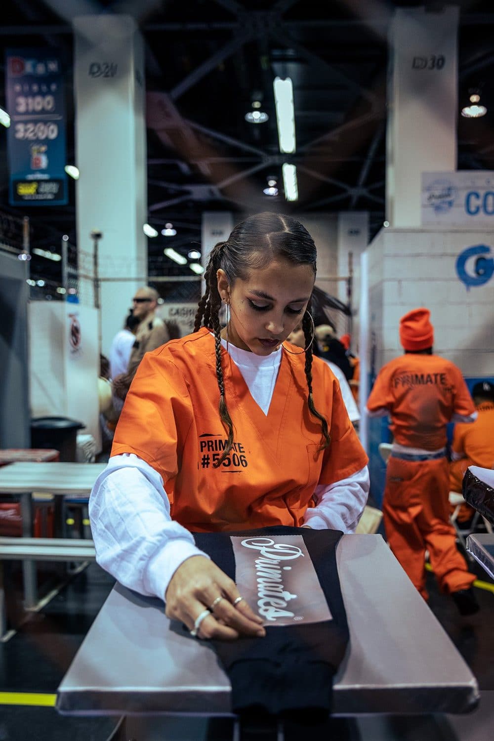Booth staff, in Primate jumpsuits, packing apparel.